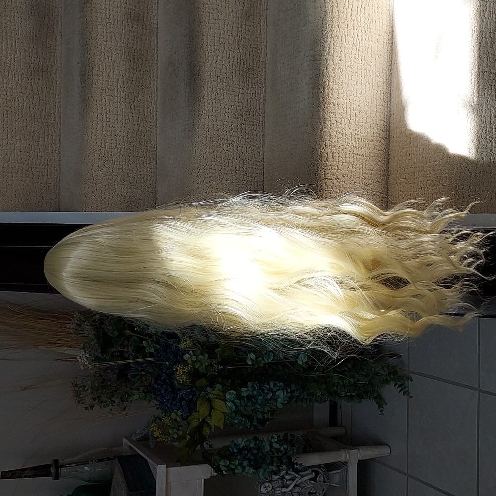 Brand new long synthetic bleached blond wig with loose curls